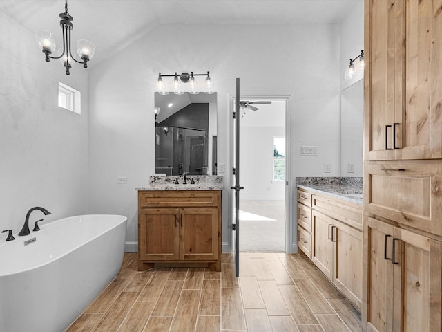 bathroom featuring lofted ceiling, vanity, a notable chandelier, and independent shower and bath