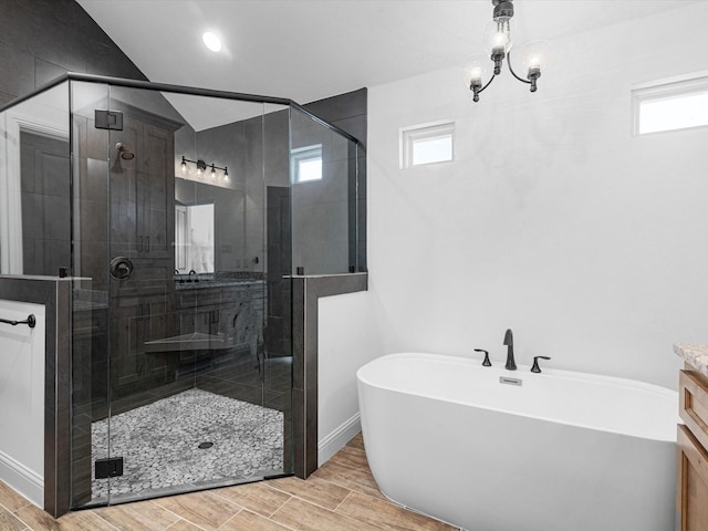 bathroom featuring vaulted ceiling, vanity, and separate shower and tub