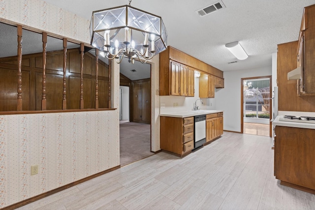 kitchen featuring extractor fan, a textured ceiling, hanging light fixtures, stainless steel dishwasher, and a notable chandelier