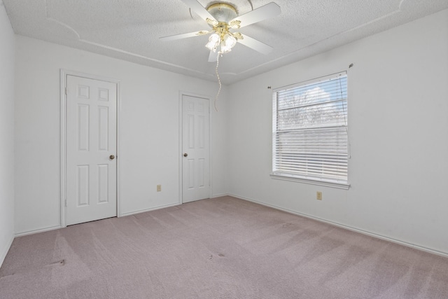 carpeted spare room featuring ceiling fan and a textured ceiling