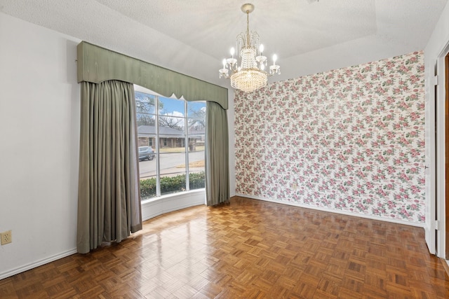 spare room with lofted ceiling, dark parquet flooring, and a textured ceiling