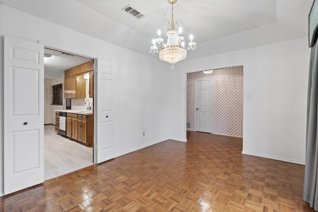 empty room featuring an inviting chandelier, sink, dark parquet floors, and a textured ceiling