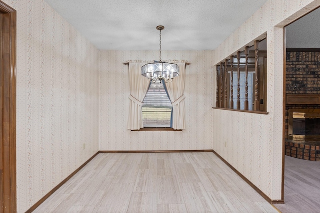 unfurnished dining area with hardwood / wood-style floors, a chandelier, and a textured ceiling