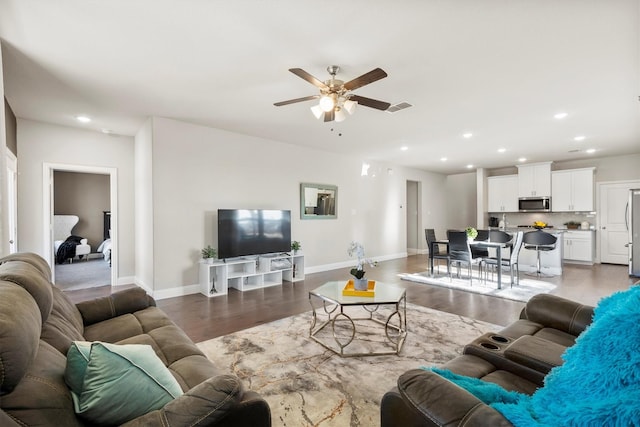 living area with baseboards, wood finished floors, visible vents, and recessed lighting