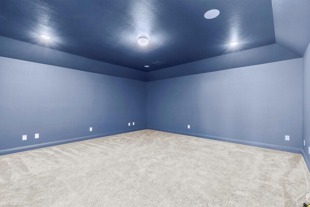 carpeted bedroom featuring lofted ceiling and multiple windows