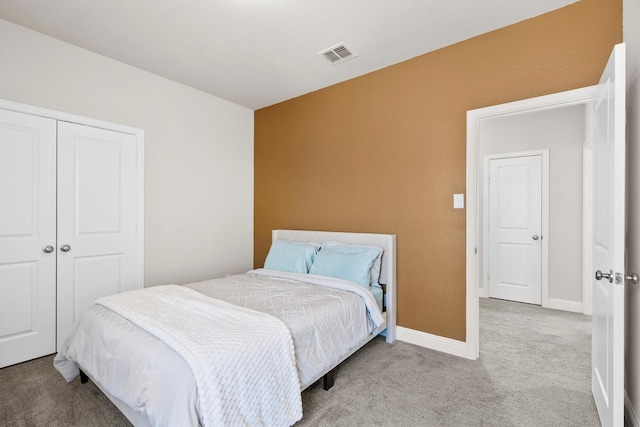 carpeted bedroom with a closet, visible vents, and baseboards