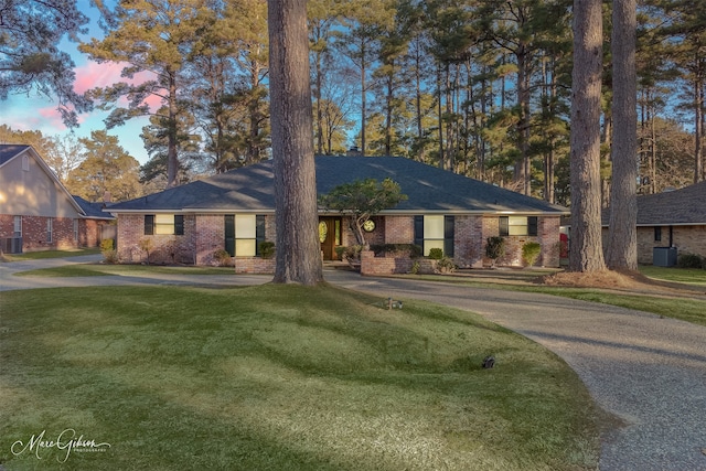 single story home featuring cooling unit and a yard