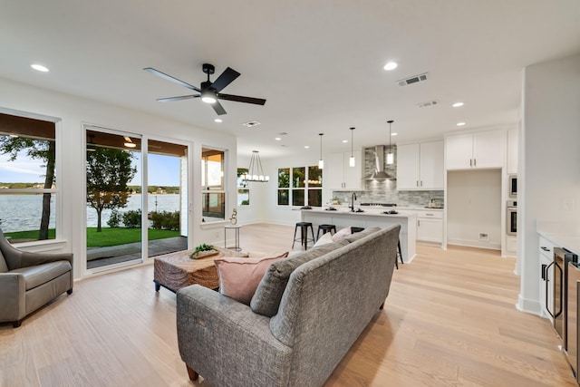 13590 Park Harbor Dr, Eustace, TX 75124 - living room with a ceiling fan, light wood finished floors, recessed lighting, a water view, and a chandelier