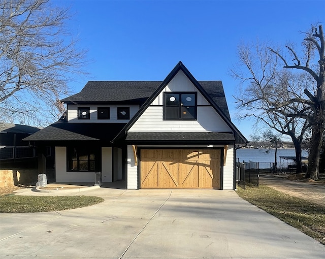 view of front of property with a garage and a water view