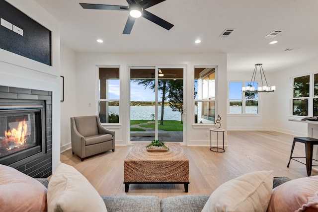 13590 Park Harbor Dr, Eustace, TX 75124 - living room with light wood-style flooring, a glass covered fireplace, a water view, recessed lighting, and ceiling fan