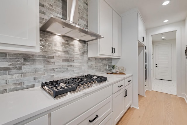 13590 Park Harbor Dr, Eustace, TX 75124 - kitchen featuring wall chimney exhaust hood, appliances with stainless steel finishes, white cabinets, light wood-type flooring, and recessed lighting