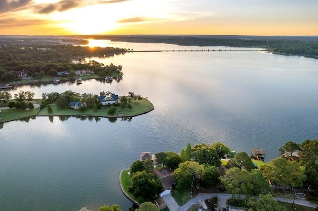 aerial view at dusk featuring a water view