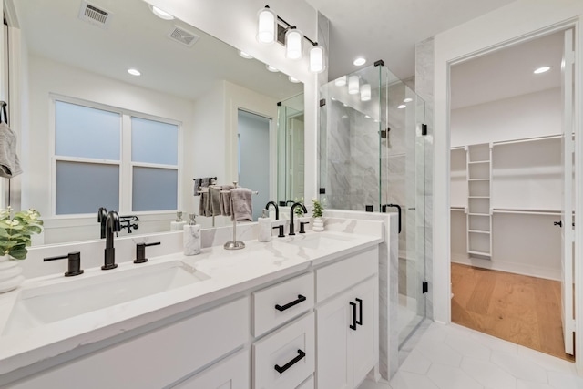 13590 Park Harbor Dr, Eustace, TX 75124 - bathroom with a walk in closet, a shower stall, double vanity, recessed lighting, and tile patterned flooring