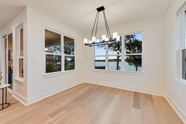 13590 Park Harbor Dr, Eustace, TX 75124 - unfurnished dining area featuring a chandelier, light wood-style flooring, plenty of natural light, and a water view