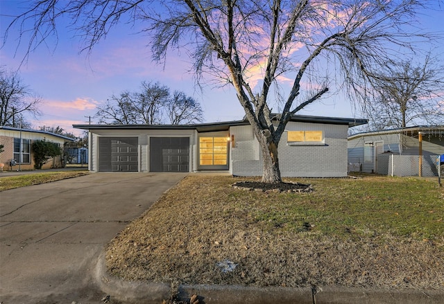 ranch-style house featuring a garage and a lawn