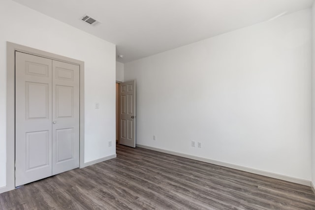 unfurnished bedroom featuring dark hardwood / wood-style floors and a closet