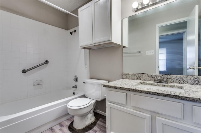 full bathroom with vanity, hardwood / wood-style flooring, toilet, and tiled shower / bath