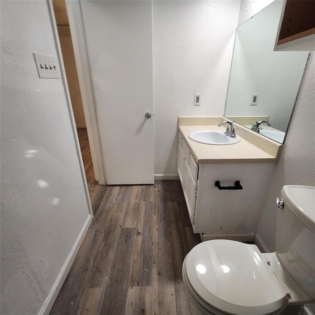 bathroom featuring vanity, hardwood / wood-style flooring, and toilet