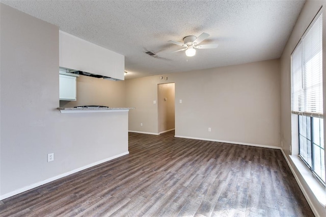 unfurnished living room featuring a textured ceiling, wood-type flooring, and ceiling fan