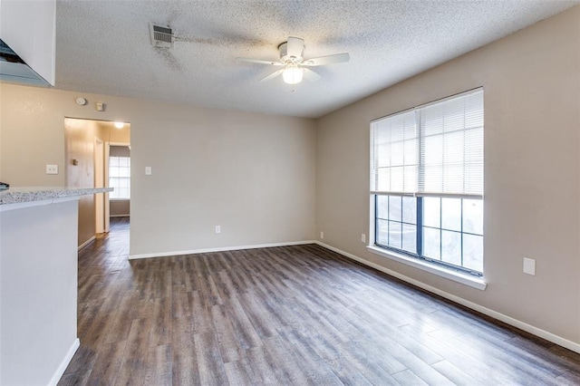 unfurnished room featuring dark hardwood / wood-style flooring, a textured ceiling, and ceiling fan