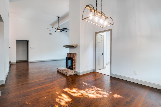 unfurnished living room featuring a fireplace, high vaulted ceiling, dark hardwood / wood-style floors, and beamed ceiling