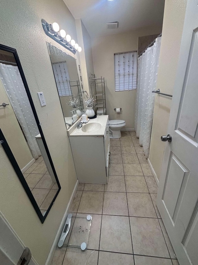 bathroom featuring vanity, tile patterned floors, and toilet