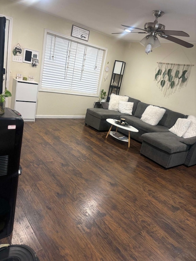 living room featuring dark wood-type flooring and ceiling fan