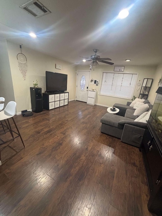 living room featuring dark wood-type flooring and ceiling fan