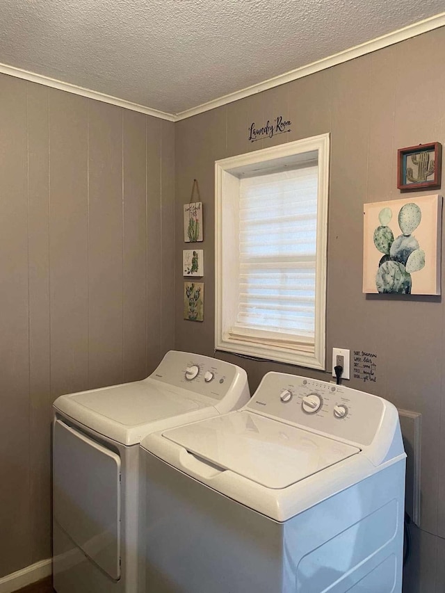 clothes washing area featuring washer and clothes dryer and a textured ceiling