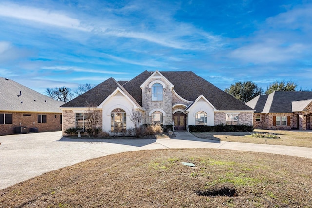 view of front facade featuring central AC unit and a front yard