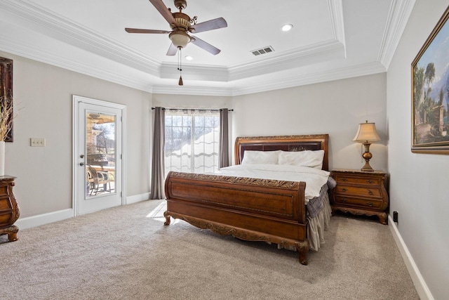 carpeted bedroom with ornamental molding, ceiling fan, and a tray ceiling