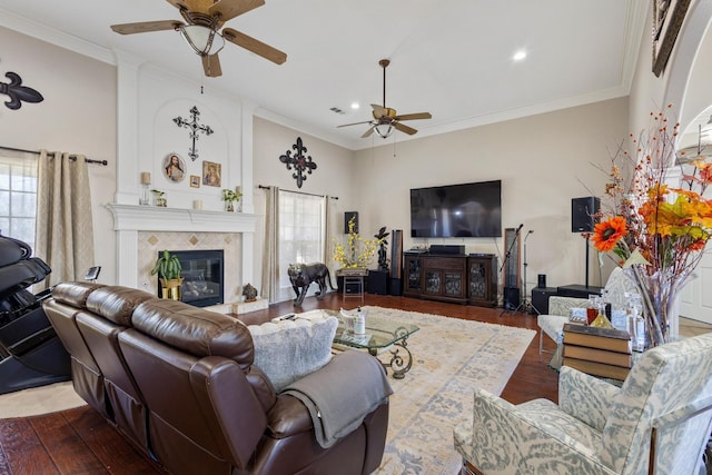 living room featuring ornamental molding, a tile fireplace, and dark hardwood / wood-style floors