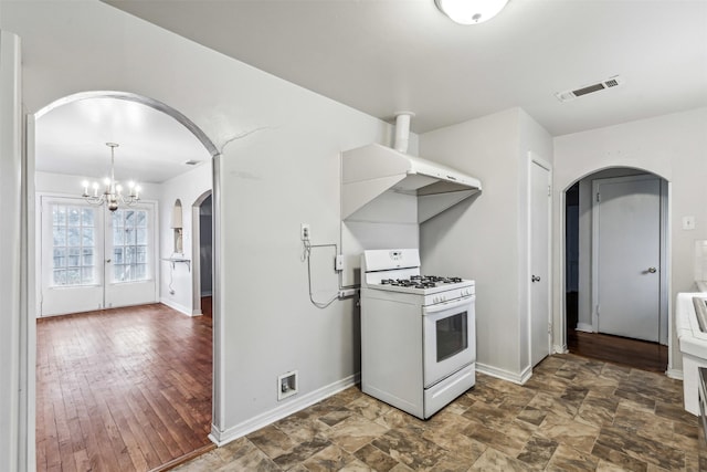 kitchen with dark hardwood / wood-style floors, white gas stove, and an inviting chandelier