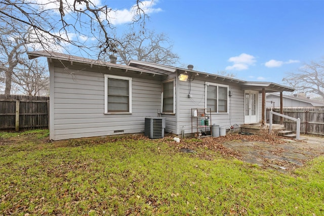 back of property with a yard and central air condition unit