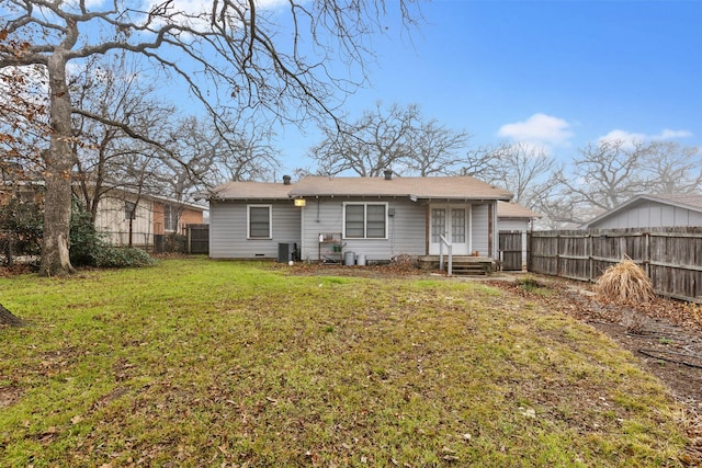 rear view of house with a yard and central air condition unit