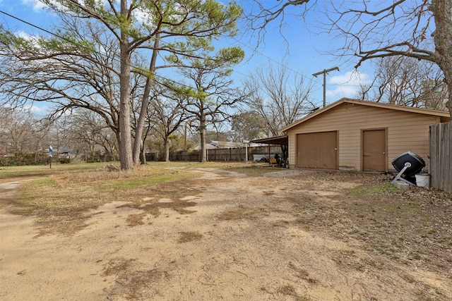 view of yard with a carport, an outdoor structure, and a garage