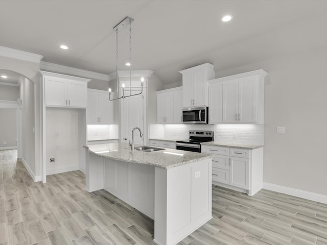 kitchen featuring stainless steel appliances, a kitchen island with sink, sink, and white cabinets