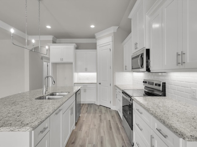 kitchen featuring white cabinetry, appliances with stainless steel finishes, sink, and a center island with sink