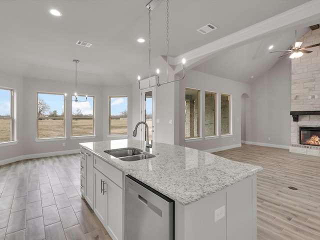 kitchen featuring sink, white cabinetry, a kitchen island with sink, hanging light fixtures, and stainless steel dishwasher