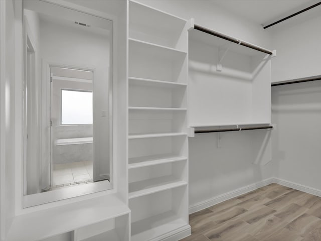 walk in closet with hardwood / wood-style floors