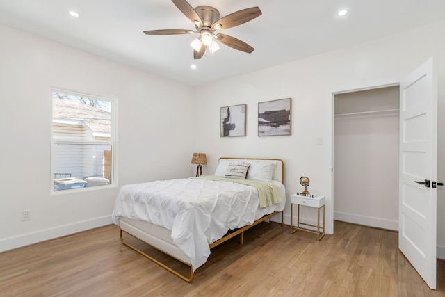 bedroom with ceiling fan, light hardwood / wood-style floors, and a closet