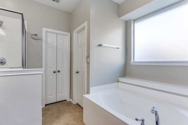 bathroom featuring tile patterned flooring and a tub