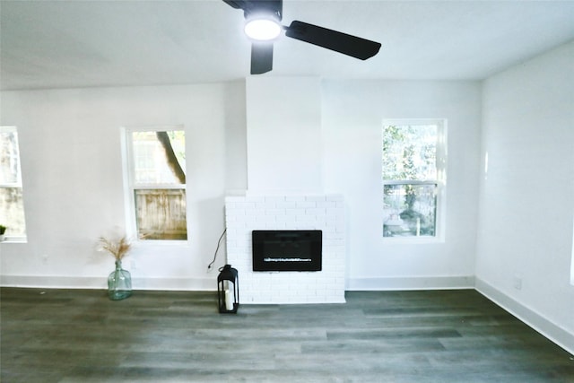 unfurnished living room with dark wood-type flooring and a brick fireplace