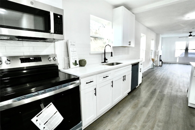 kitchen featuring sink, hardwood / wood-style flooring, white cabinetry, backsplash, and stainless steel appliances