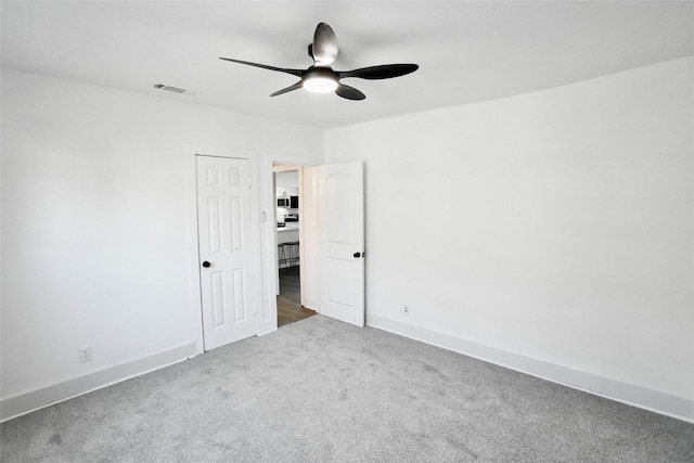 carpeted empty room featuring ceiling fan