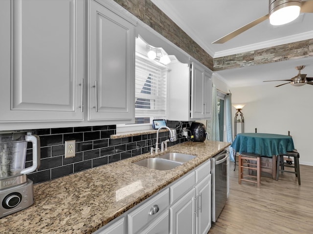 kitchen featuring sink, white cabinetry, crown molding, plenty of natural light, and dishwasher