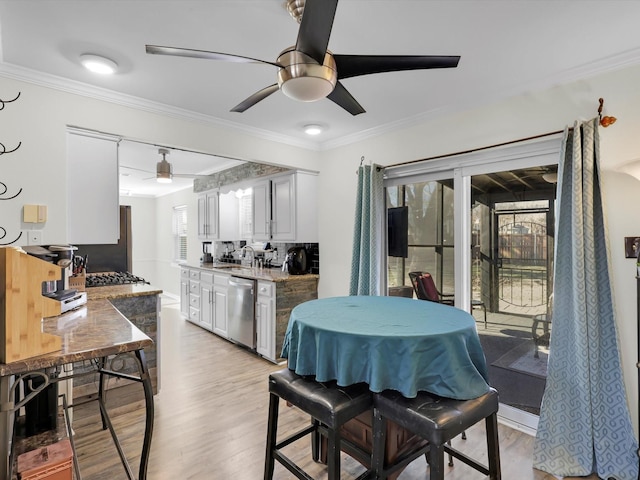 kitchen with white cabinetry, crown molding, dishwasher, and light stone counters