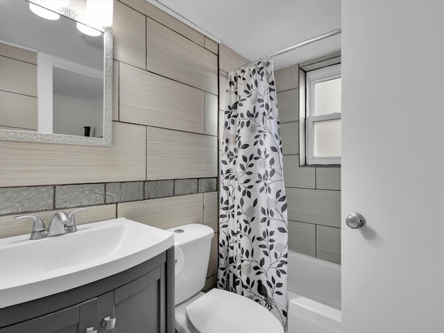 full bathroom with vanity, tile walls, shower / tub combo, and toilet