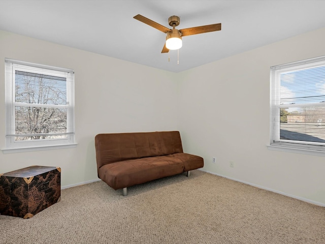 sitting room featuring ceiling fan, light colored carpet, and plenty of natural light