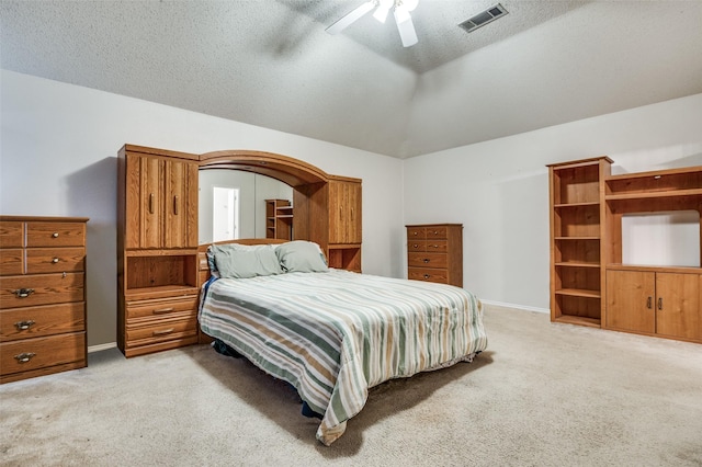 bedroom with lofted ceiling, visible vents, a textured ceiling, and light colored carpet